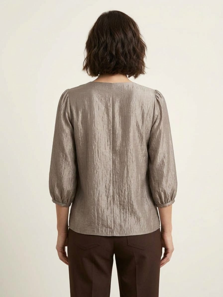 blusa-satinada-ale-gris-plata-en-modelo-vista-posterior-con-pantalon-marron